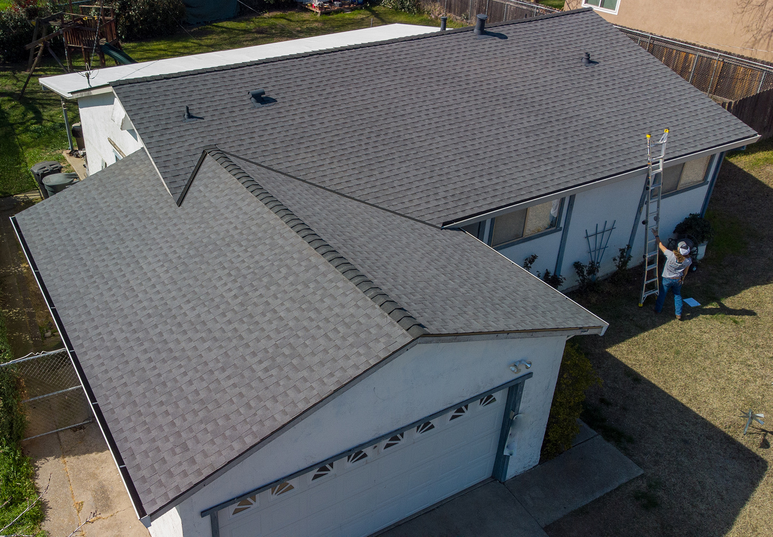 Aerial view of a dark, new roof on a house