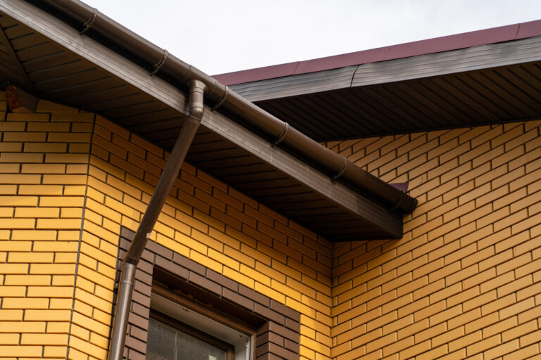 yellow brick wall gutter downspouts