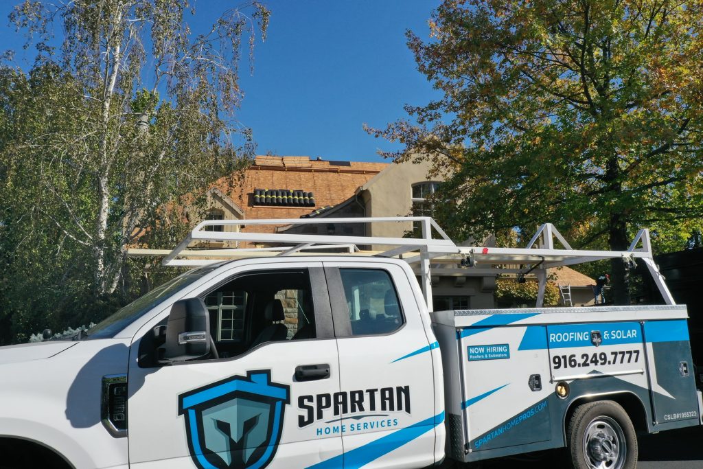 truck parked outside project roof replacement with solar panels